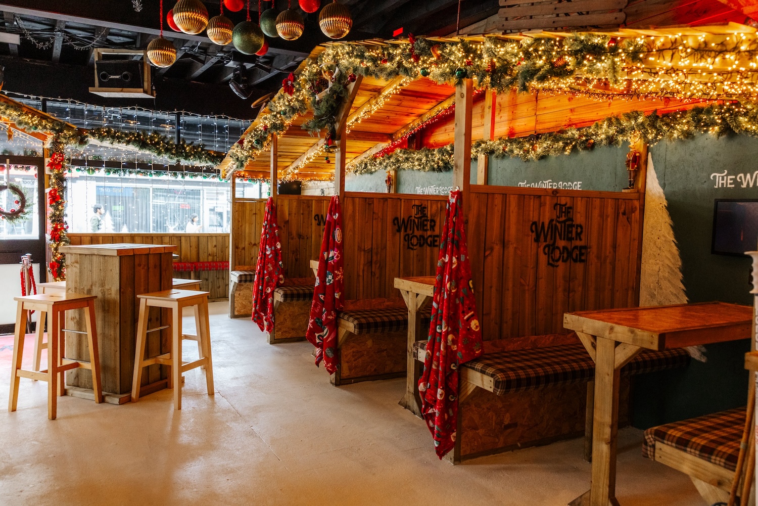 Rows of wooden huts with tartan blankets and garlands
